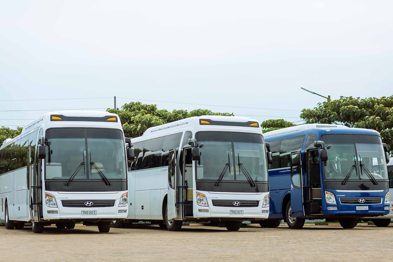 why-choose-us Three Hyundai buses parked in an outdoor parking lot on a clear day.